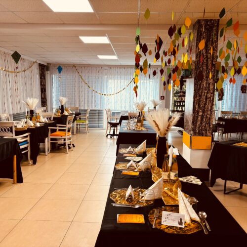 Dekorierter Speisesaal mit herbstlichen Blättern und festlich gedeckten Tischen