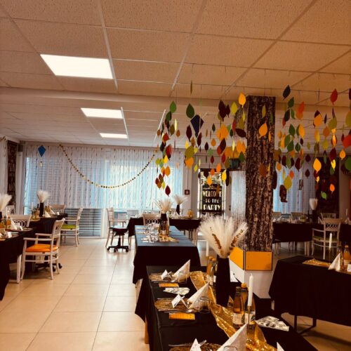 Herbstlich dekorierter Festsaal mit bunten Blättern und einladend gedeckten Tischen